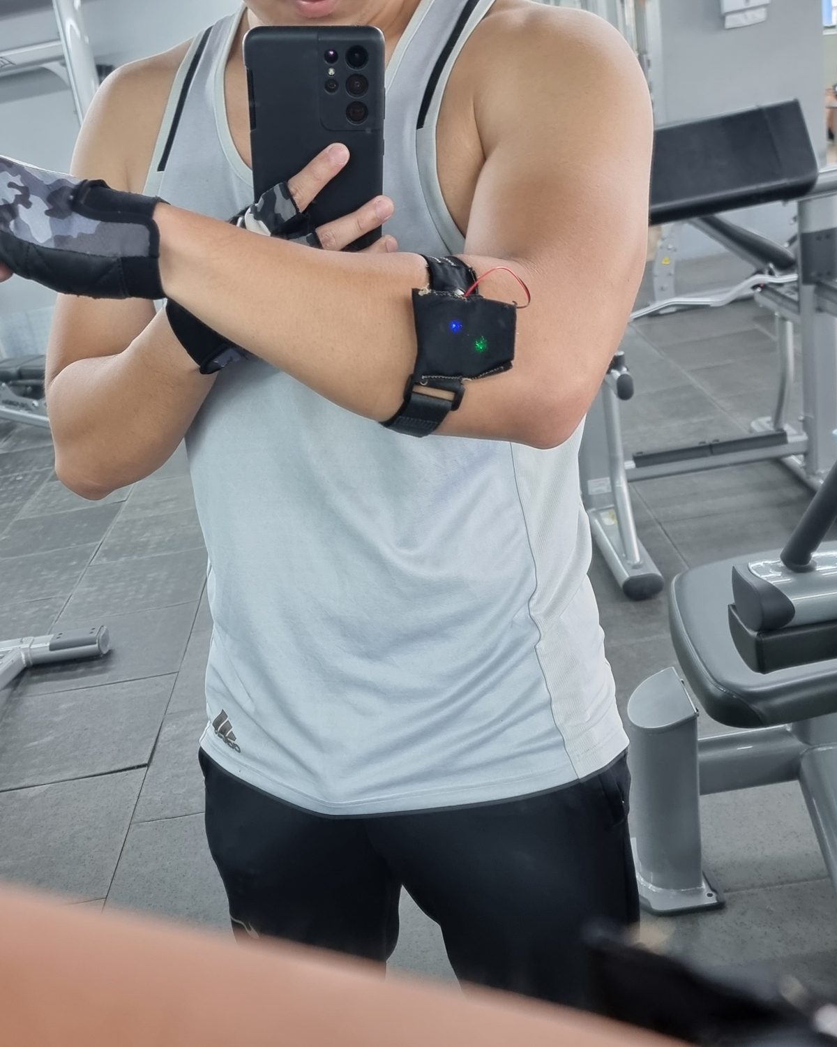 Me at the gym in 2022, wearing the first hand-sewn ARIS prototype on my arm
