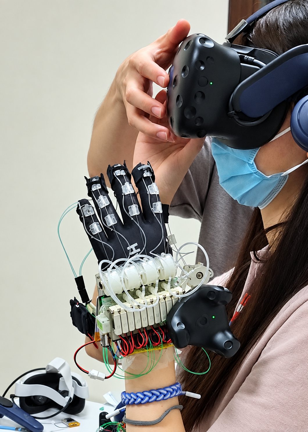 The early haptic glove at NUS: tubes, valves and a VR tracker on the wrist